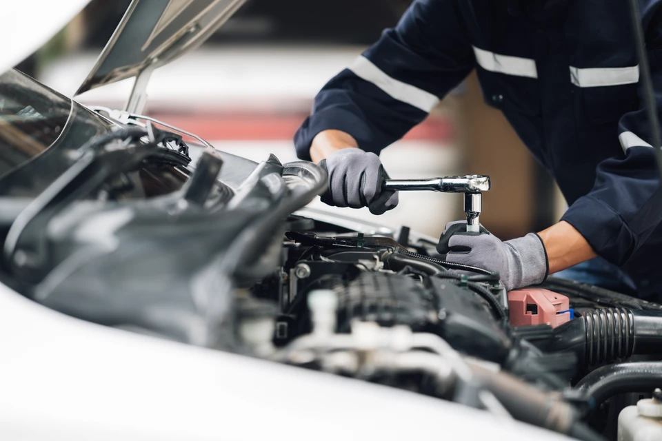 Mécanique travaille sur le moteur de la voiture dans le garage