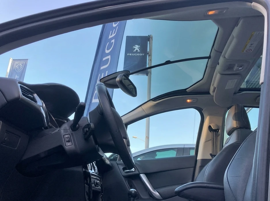 Intérieur d'un véhicule Peugeot vu depuis la portière ouverte côté conducteur