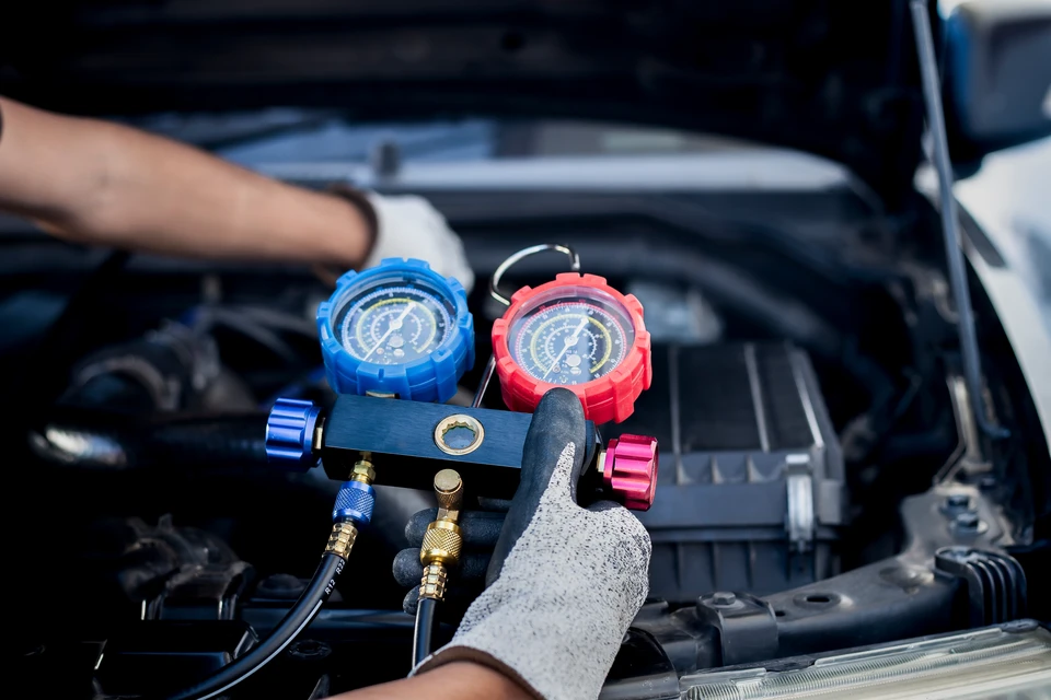 Mécanique à l'aide d'une clé de serrure pendant qu'on travaille sur un moteur de voiture à l'atelier de garage, les services de voiture et le concept de contrôle de maintenance