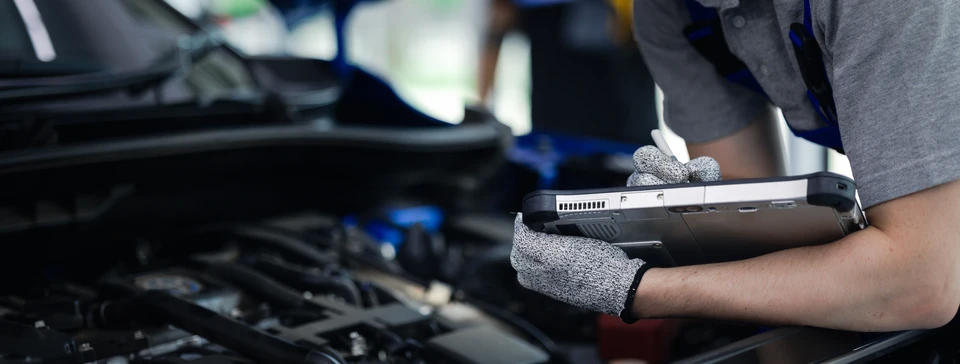 Scène intérieure d'un atelier automobile avec deux personnes échangeant des clés de véhicule